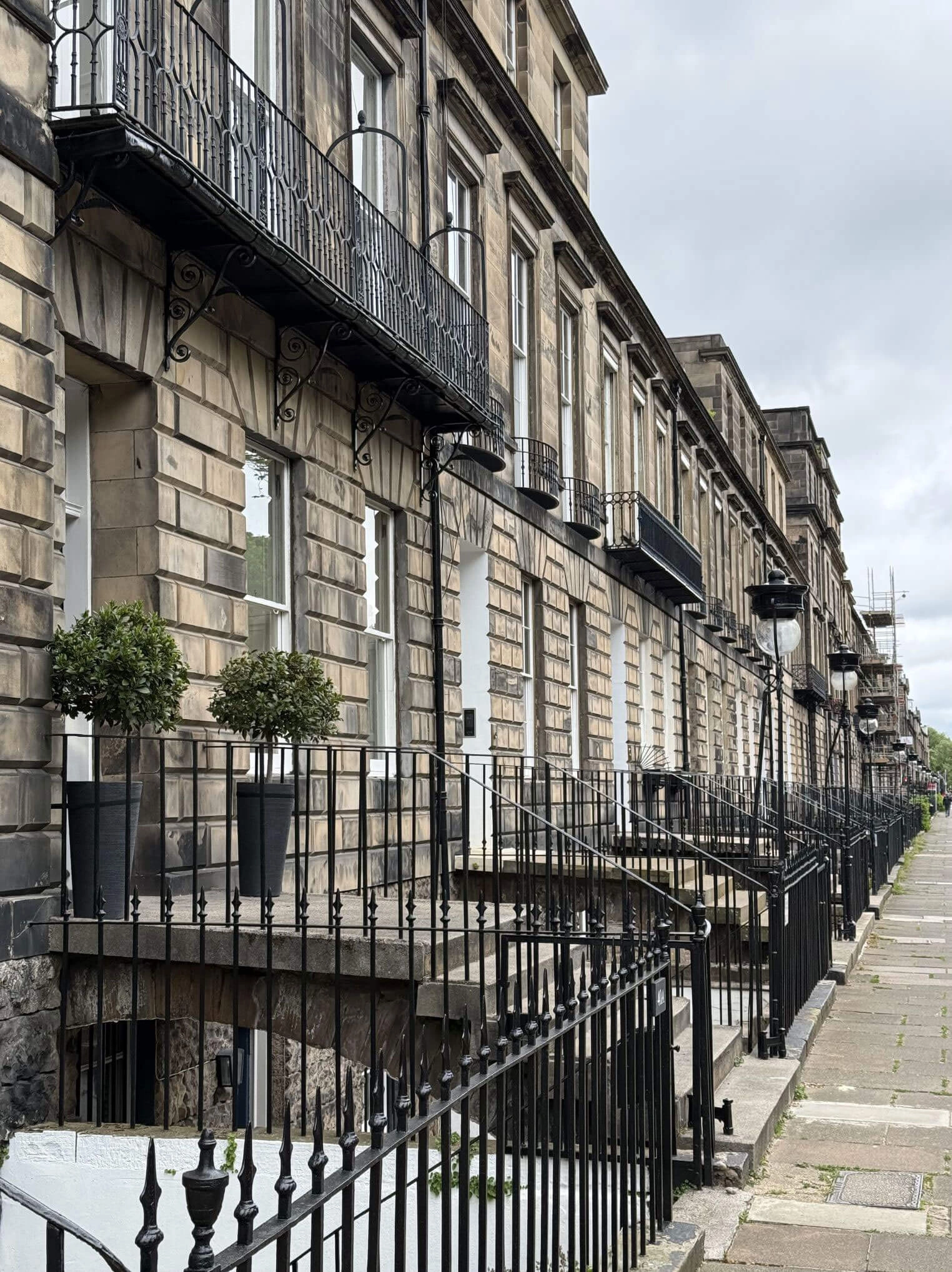 Steps and iron railings beside a row of stone entrances