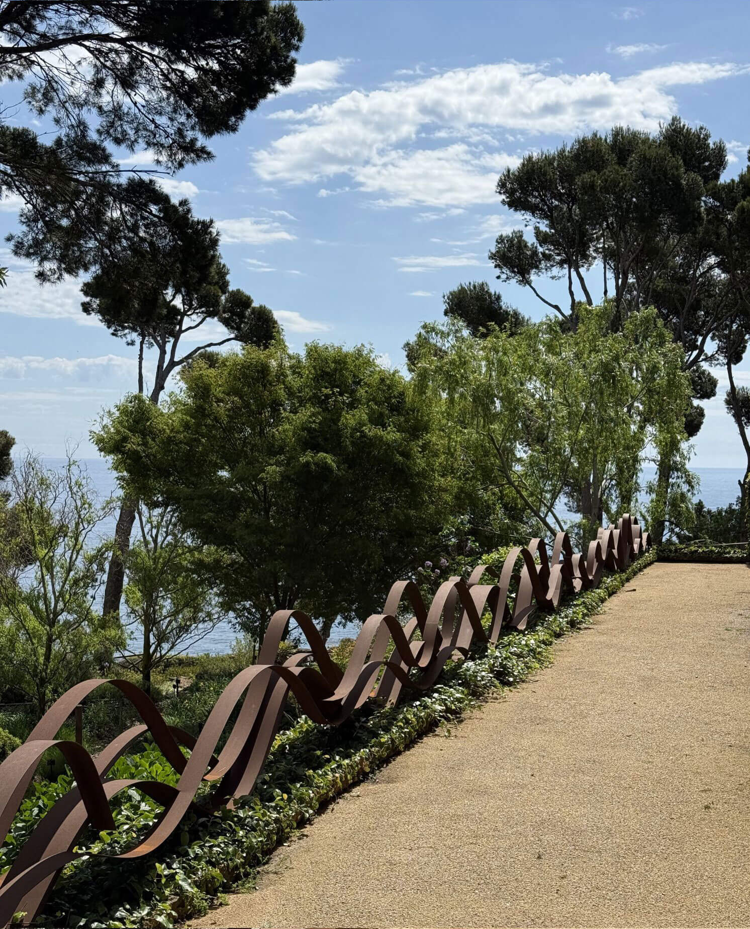 Curving sculptural railing along a coastal garden path