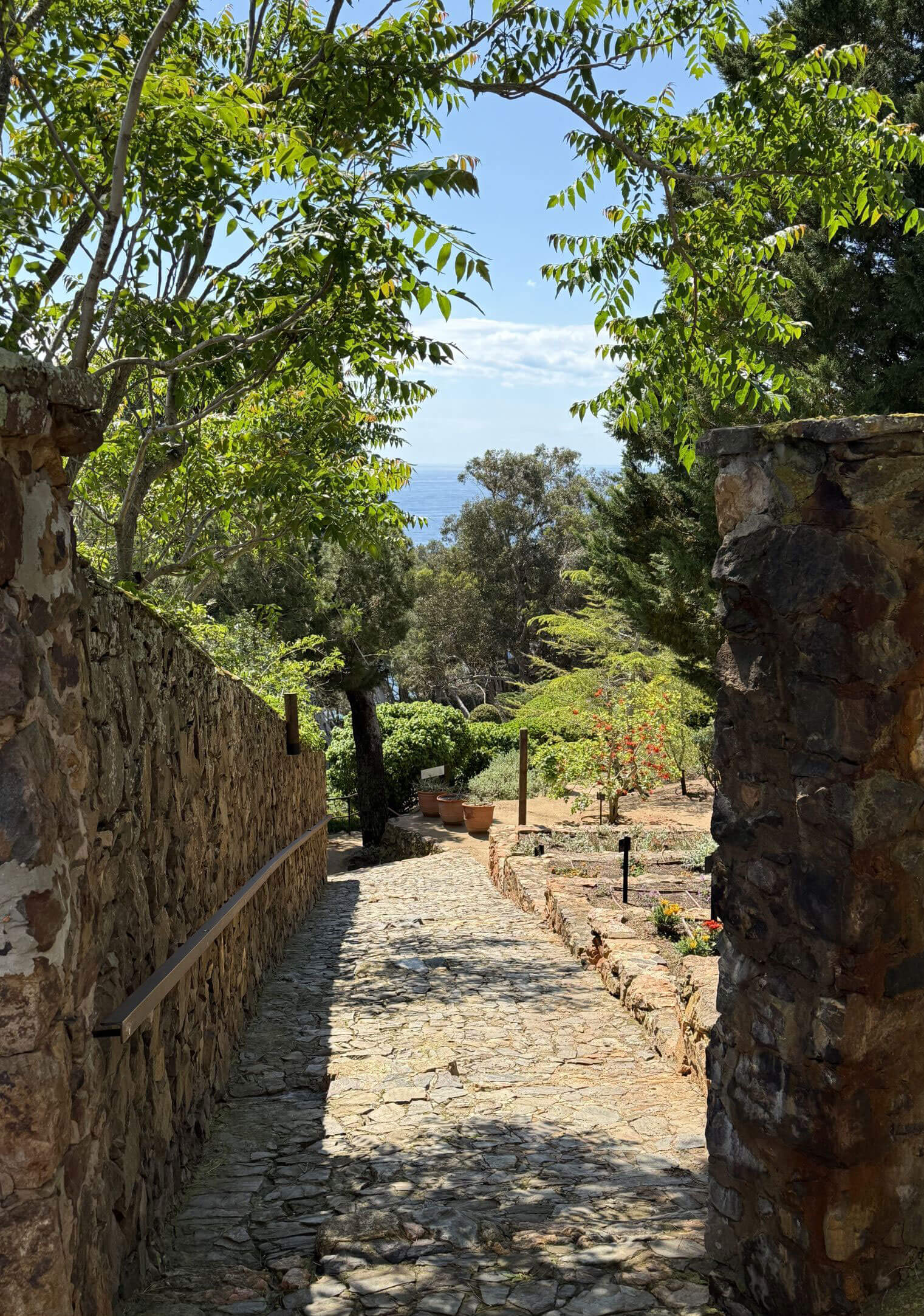 Shaded cobbled path between rustic stone walls
