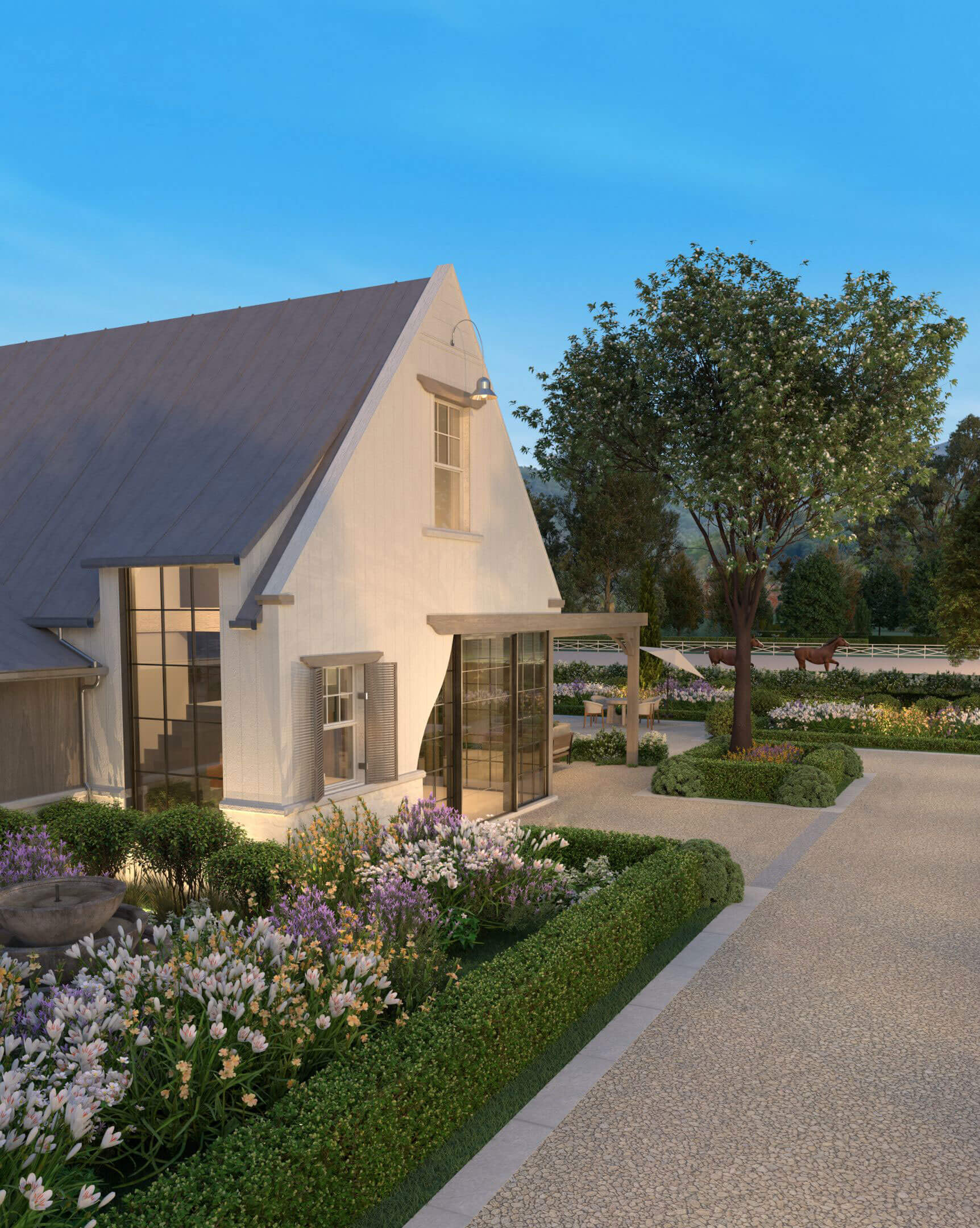 Riding arenas bordered by white fencing and gardens