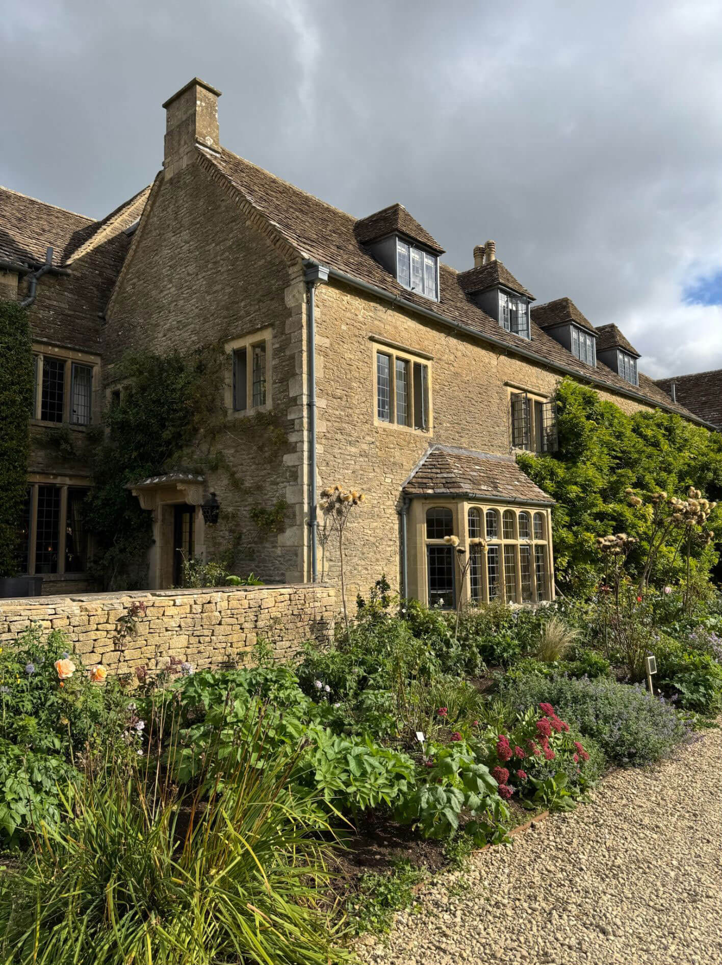 Stone manor wing with climbing foliage and projecting windows