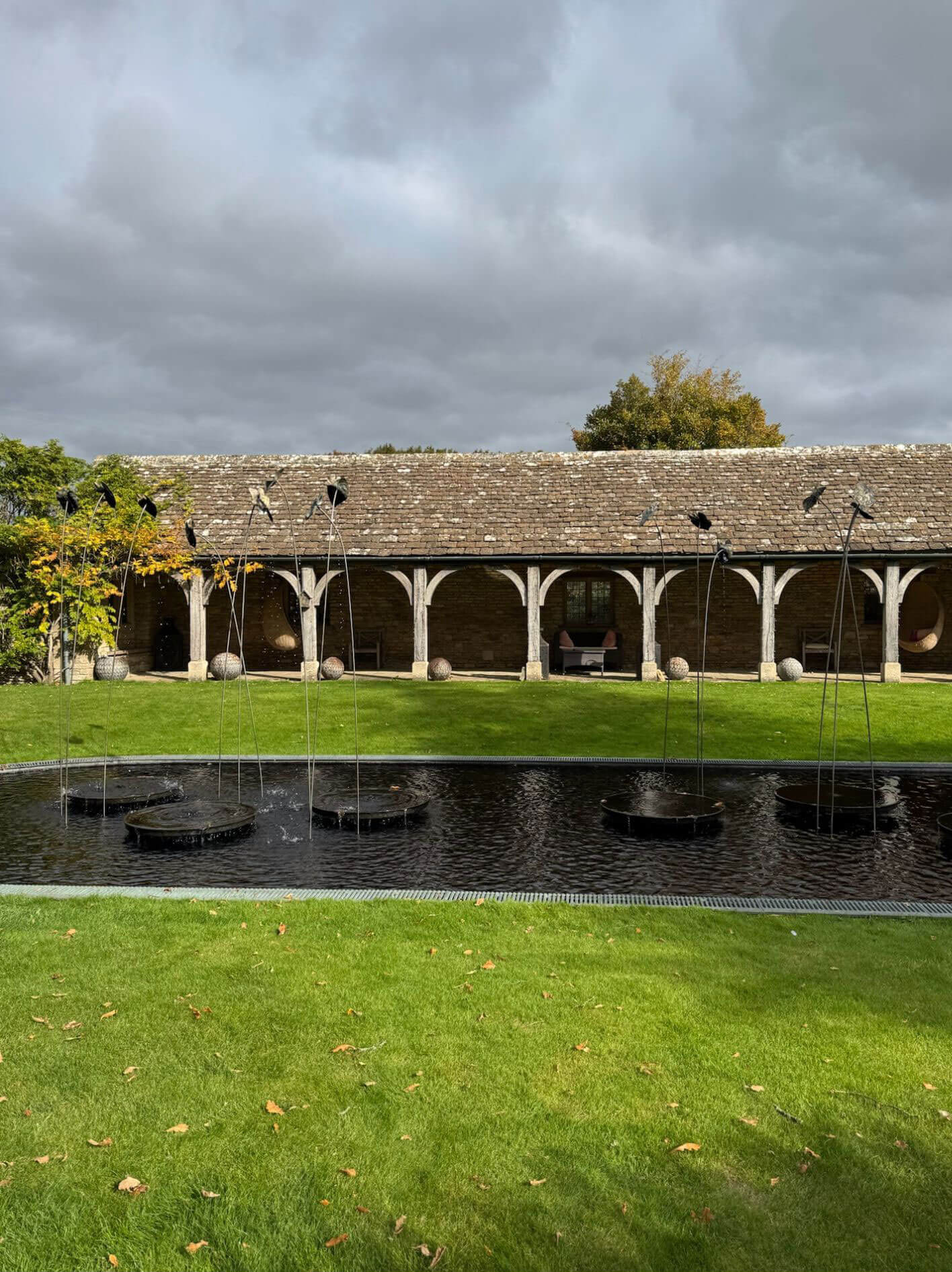 Garden pond and lawn beside a covered timber walkway
