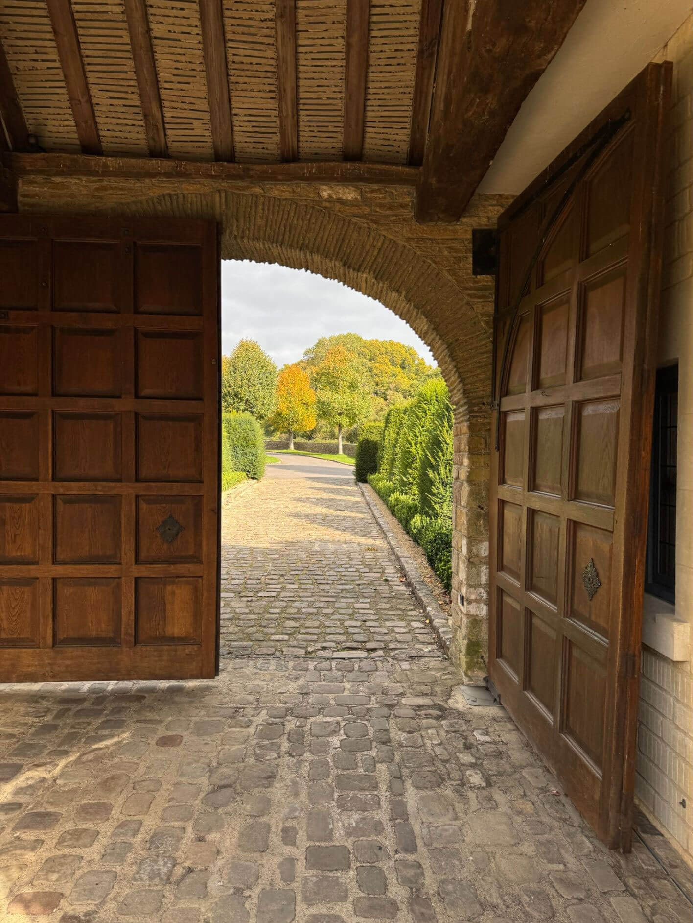 View through an open timber gate toward the gardens