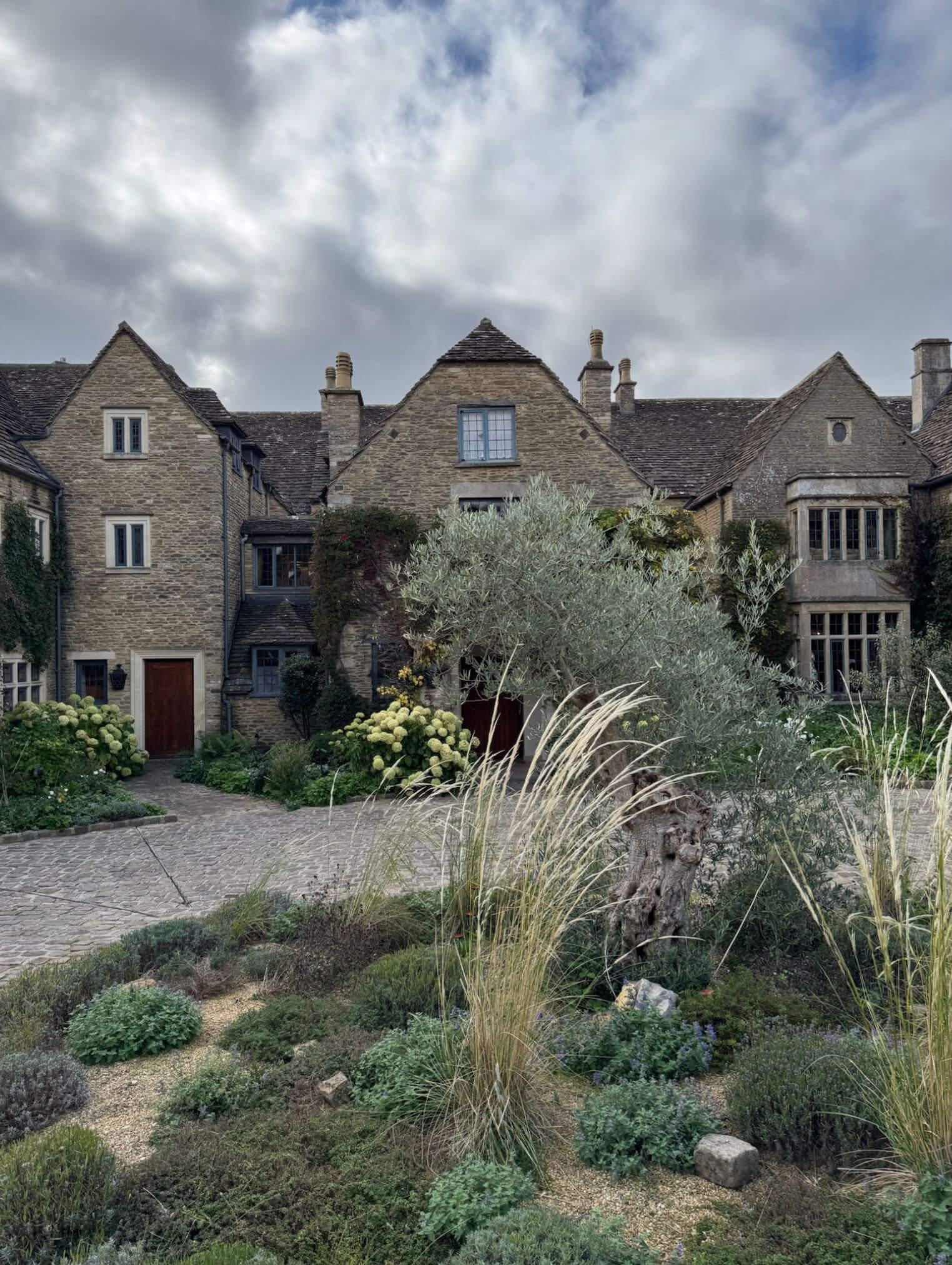 Courtyard planting in front of gabled stone wings