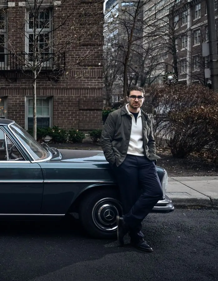 Jesse Sahlani standing beside a classic car on a tree-lined city street