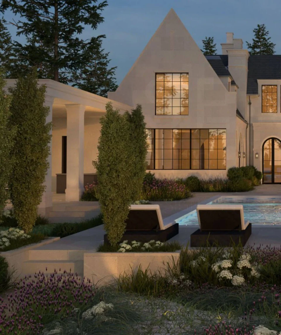 Garden seating and flowering borders beside a pale stone home with steep gables