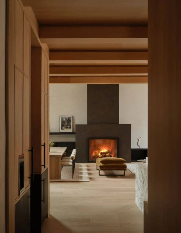 View through timber-framed doorways to a living room with a fireplace